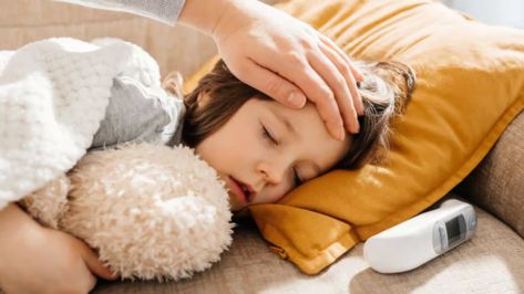 kid having fever lying on the bed